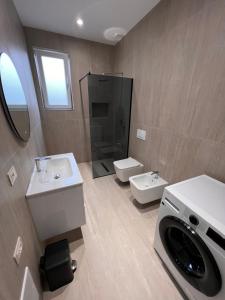 a bathroom with a sink and a washing machine at Aron apartments in Tirana +18 photos