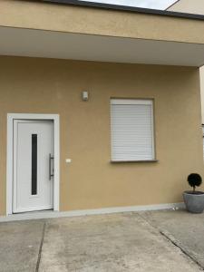 a house with a white door and a window at Aron apartments in Tirana