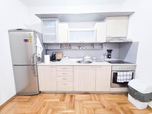 a kitchen with white cabinets and a stainless steel refrigerator at The Place FREE PARKING in Skopje +42 photos