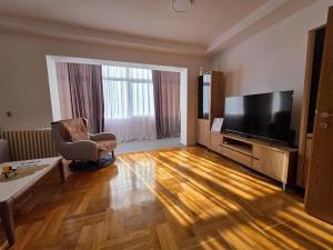 a living room with a television and a chair at The Place FREE PARKING in Skopje