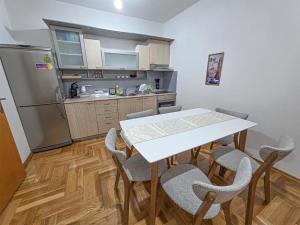 a kitchen with a table and chairs and a refrigerator at The Place FREE PARKING in Skopje