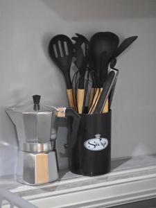 a black cup filled with utensils on a shelf at The Place FREE PARKING in Skopje