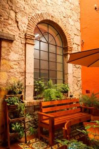 a wooden bench sitting in front of a building at Navarrete 63 Hotel in Morelia