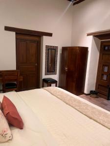 a bedroom with a large bed and a wooden door at Navarrete 63 Hotel in Morelia