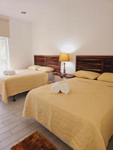 a hotel room with two beds with towels on them at Apartamento Arrecife in Tela +6 photos