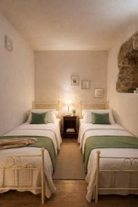 a bedroom with two beds and a table with a lamp at Cilento House with Garden & Sunset View in Sessa Cilento