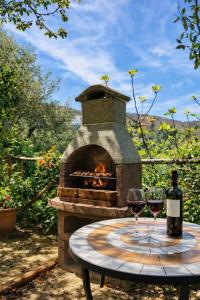 a table with two wine glasses and a stone oven at Cilento House with Garden & Sunset View in Sessa Cilento