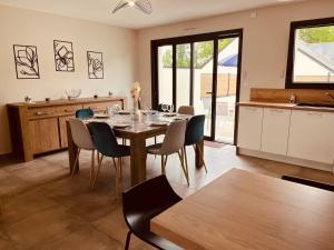 a kitchen and dining room with a table and chairs at Maison moderne 3 chambres SPA-jacuzzi mai-septembre in Cerelles