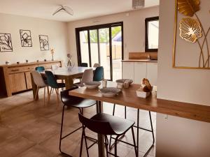 a kitchen and dining room with a table and chairs at Maison moderne 3 chambres SPA-jacuzzi mai-septembre in Cerelles