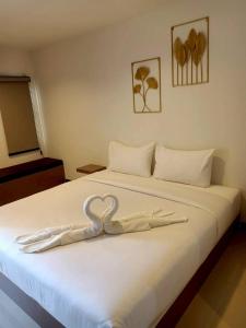 a white bed with a heart decoration on it at Wish Resident Ubonratchathani in Ban Nong Bua