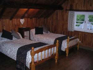 1 dormitorio con 2 camas y ventana en Maison Lacoste en Campan