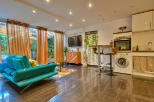 a living room with a blue couch and a kitchen at The Beach Dream in Saint-Laurent-du-Var