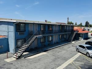 a blue building with stairs in a parking lot at Imperial Inn & Suites in Norwalk