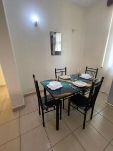 a dining room table with black chairs and a blue table at Pristine Home - Cozy Luxury Residence in Mtwapa +8 photos