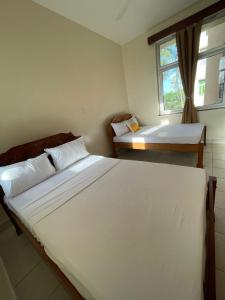 a bedroom with two beds and a window at Pristine Home - Cozy Luxury Residence in Mtwapa