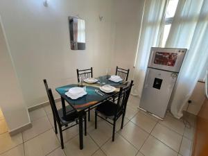a dining room with a table with chairs and a refrigerator at Pristine Home - Cozy Luxury Residence in Mtwapa