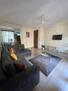 a living room with a couch and a table at Pristine Home - Cozy Luxury Residence in Mtwapa