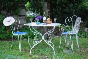 a table with two chairs and a table with wine glasses at Maison Lacoste in Campan