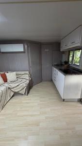 a room with a bed and a kitchen in a house at Casinha das bonecas in Adenodeiro