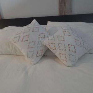 two white pillows sitting on top of a bed at Endless Summer in Summerland +10 photos