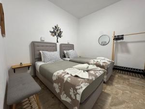 a bedroom with two beds and a chair at Yanna's Apartments in Sidari