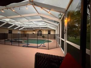 a patio with a pool with a fence and lights at Acreage Oasis - 5 Bedrooms, Pool, Space, Serenity in West Palm Beach