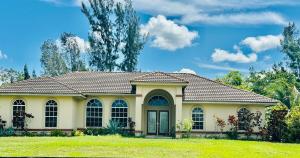 a small house with a green lawn at Acreage Oasis - 5 Bedrooms, Pool, Space, Serenity in West Palm Beach