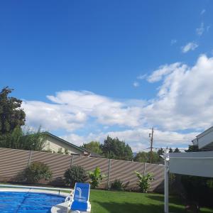 a blue chair sitting next to a swimming pool at Endless Summer in Summerland