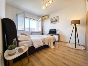 a bedroom with a bed and a table with a lamp at Prime Main Square Location in Skopje +19 photos