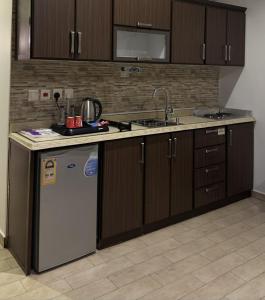 a kitchen with a white refrigerator and a sink at شقق لافينا للوحدات السكنية - المخدومة - اقتصادي in Hail
