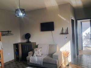 a living room with a chair and a flat screen tv at Espaço Meditare in Socorro