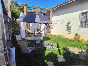 a patio with a table and chairs and an umbrella at Espaço Meditare in Socorro