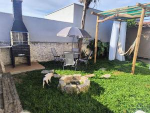 a garden with an umbrella and a table and chairs at Espaço Meditare in Socorro