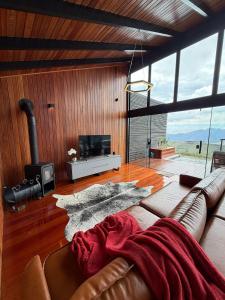 a living room with a couch and a fireplace at Chalé A-Frame - Chalé de Cima in Ouro Preto