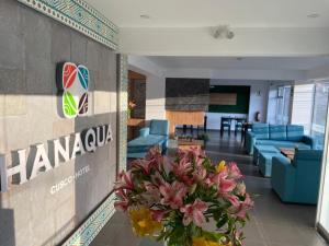 a lobby with a vase of flowers next to a sign at Hanaqua Cusco Hotel in Cusco