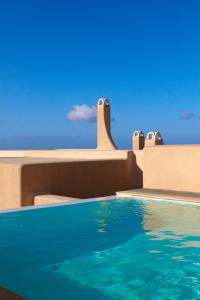 a swimming pool with the ocean in the background at Voreina Gallery Suites in Pyrgos
