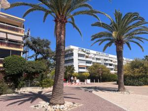 two palm trees in front of a building at The Beach Dream in Saint-Laurent-du-Var