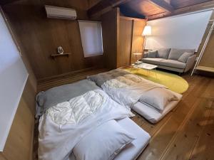 ein Zimmer mit zwei Betten und einer Couch in der Unterkunft kakiha in Atawa
