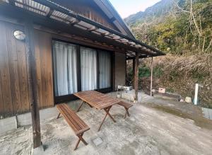 ein Holztisch und eine Bank auf einer Terrasse in der Unterkunft kakiha in Atawa