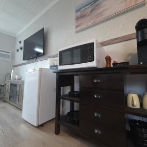 a kitchen with a microwave and a refrigerator at Endless Summer in Summerland