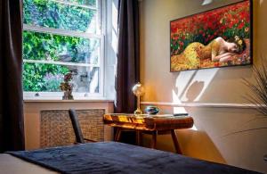 a room with a desk and a painting on the wall at Ferndale Mews in Bristol