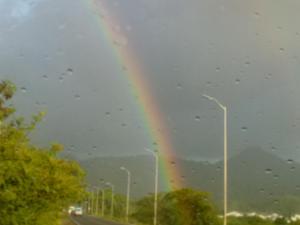 a rainbow in the sky over a road at Mabouya Villas in Dennery