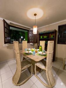 a dining room with a wooden table and chairs at Chalé Esmeralda in Gravatá