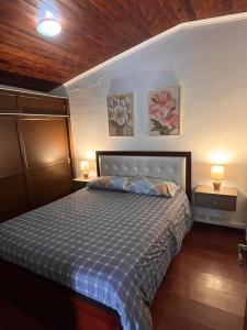 a bedroom with a bed with two night stands and two lamps at Rincón de Paz y Tranquilidad in Ambato