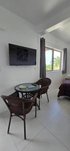 a living room with a table and chairs and a television at Ocean Beach Town View - Pool With Amazing Views! in Rarotonga
