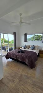 a bedroom with a large bed with a large window at Ocean Beach Town View - Pool With Amazing Views! in Rarotonga +22 photos