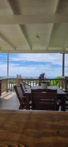 a patio with a table and chairs on a deck at Ocean Beach Town View - Pool With Amazing Views! in Rarotonga