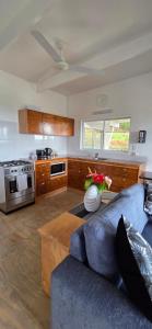 a living room with a blue couch and a kitchen at Ocean Beach Town View - Pool With Amazing Views! in Rarotonga