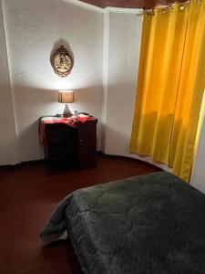 a bedroom with a bed and a table with a lamp at Rincón de Paz y Tranquilidad in Ambato