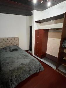 a bedroom with a large bed and a dresser at Rincón de Paz y Tranquilidad in Ambato